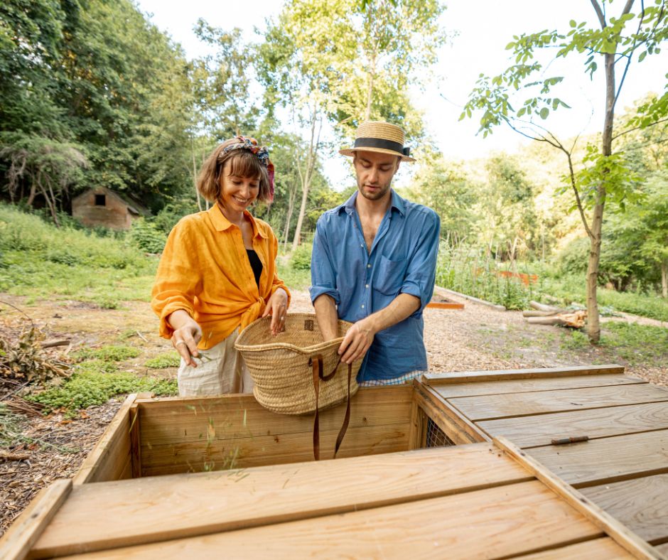 Man and woman throwing compost material and compost holder in garden