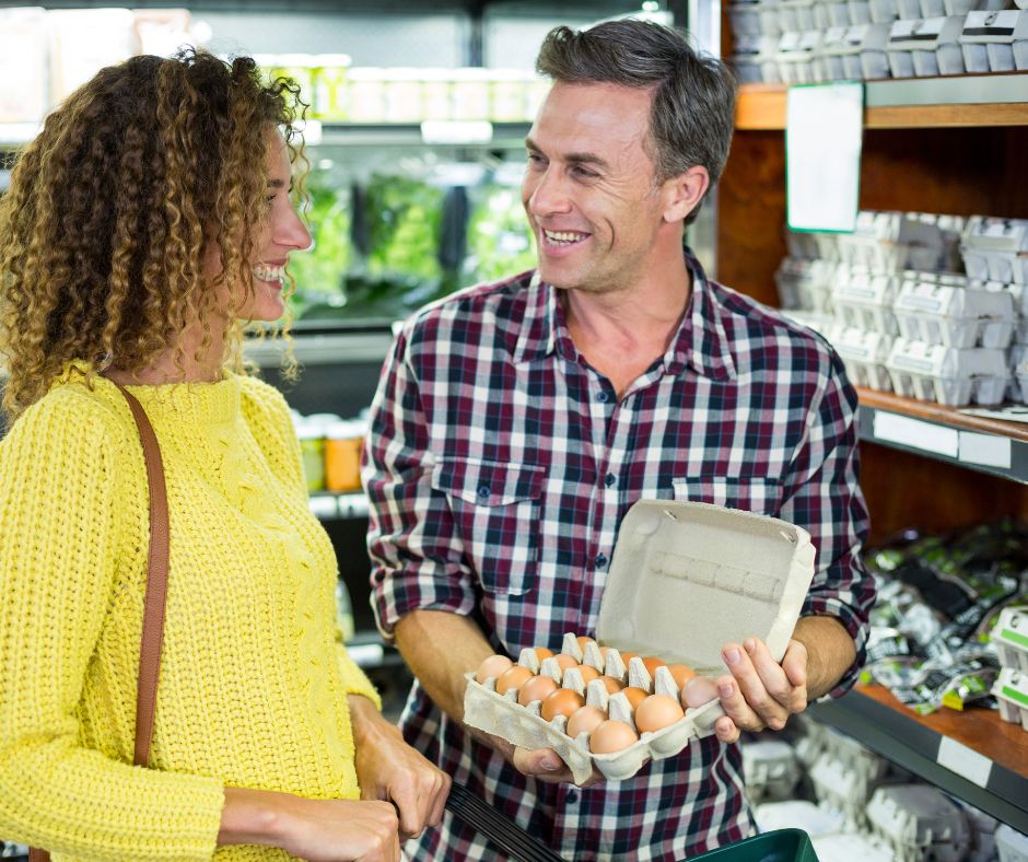 Main showing egg carton to lady in store